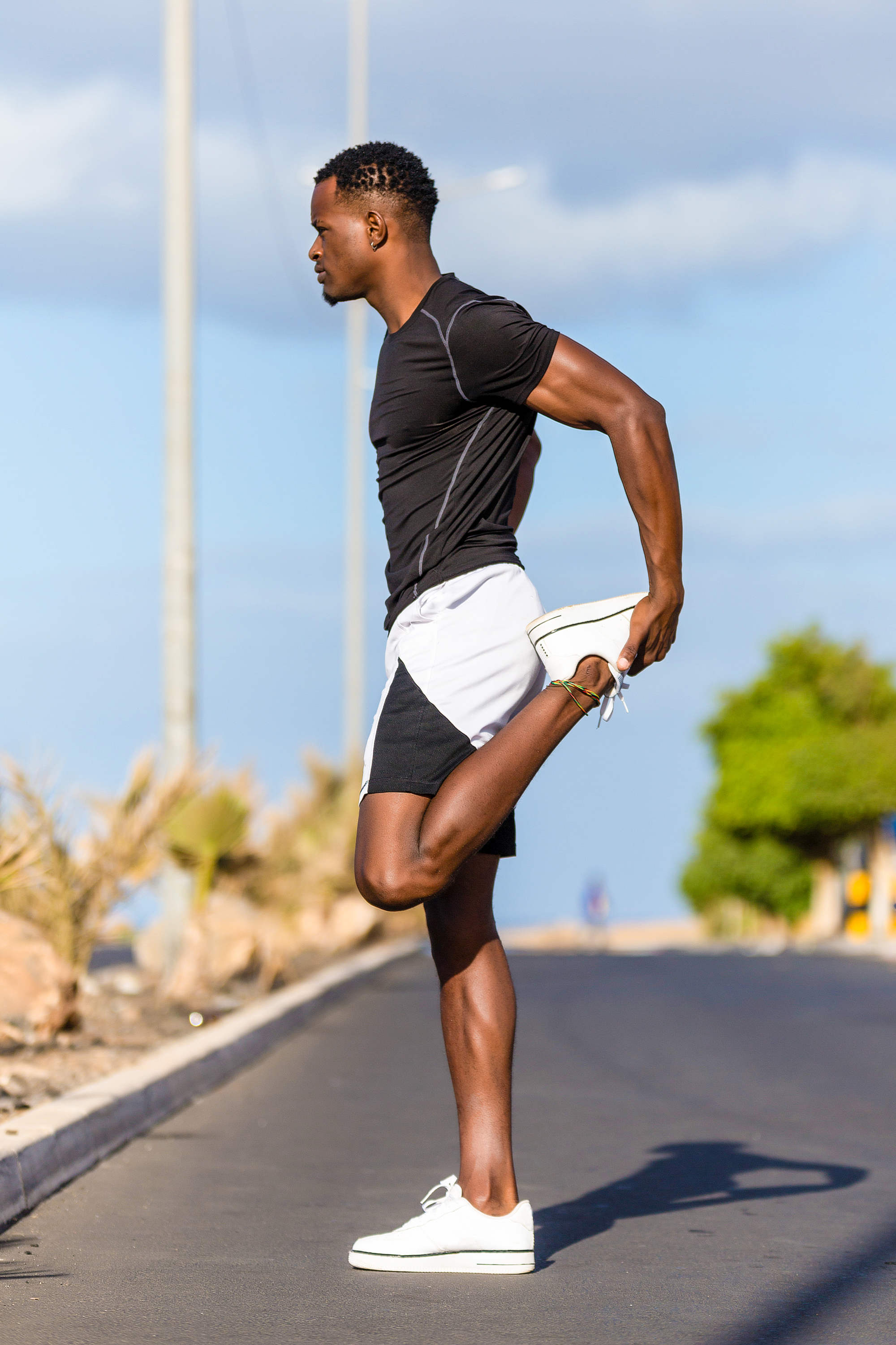 Black african american young man stretching after outdoor jogging