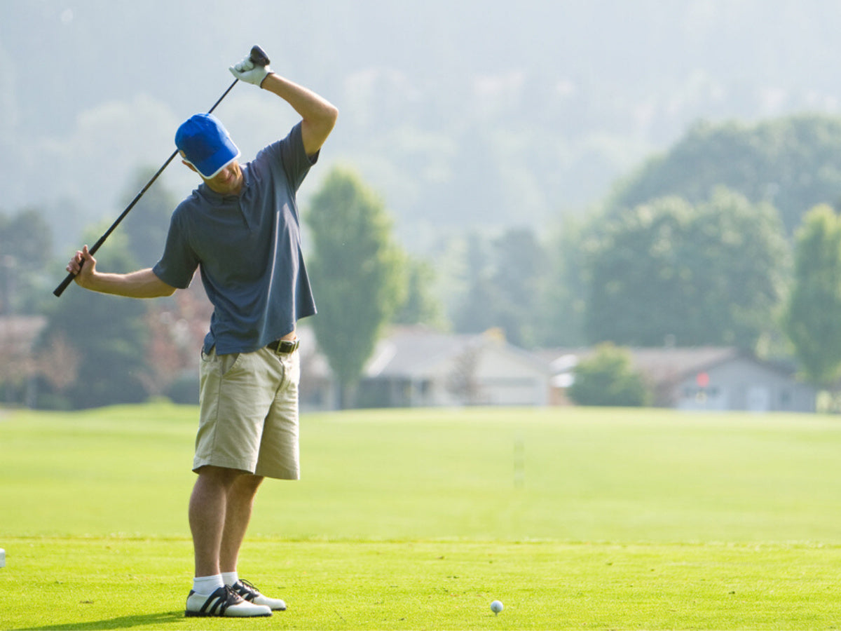 Young man stretching before golfing on a sunny day