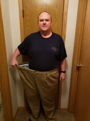 Photo of Jason holding the pants that he used to wear.