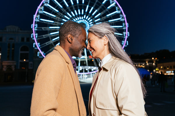 Couple on a date in front of ferris wheel.