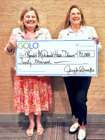 Jen Brooks presents an honorary check to Pamela W. Cornforth, President and CEO, Ronald McDonald House, Delaware