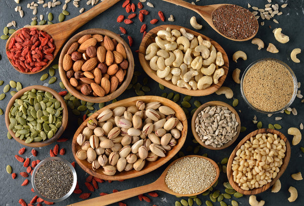 Top down view of various nuts and seeds on a table.