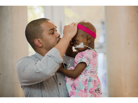 Man comforting a small child in a hospital