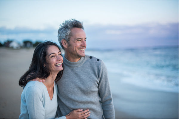 Happy couple standing on the beach.