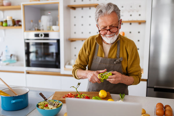 Photo of a man preparing a meal consisting of healthy foods