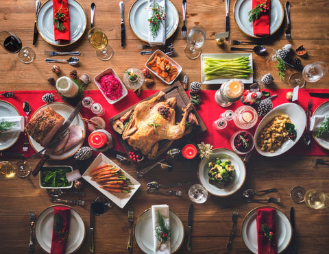 View of a long table from above with 8 place settings and an elaborate holiday feast