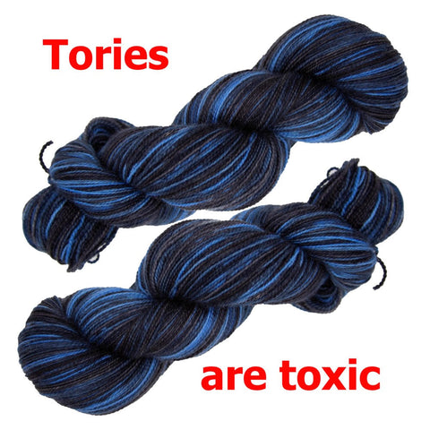 two skeins yarn laying diagonally with text in red saying tories are toxic. the yarn colour is a deep blue mixed in with black. 