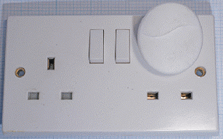 Image showing a plug socket cover upside down, exposing live parts of the socket