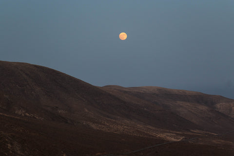 Full moon rising over barren hills representing the calming effect of solution-focused hypnotherapy