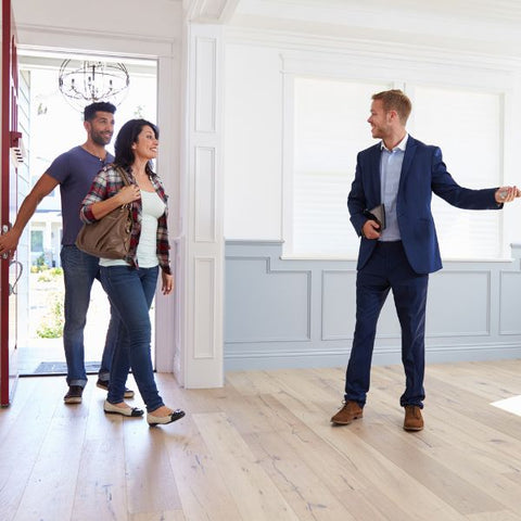 realtor showing home to a smiling couple