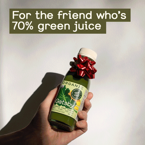 For the friend who's 70% green juice. A person holds a bottle of Gatsby with a red bow on it.