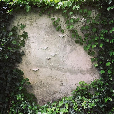 Ein Vogelschwarm aus Keramik durchbricht die Wand mit elegantem Design