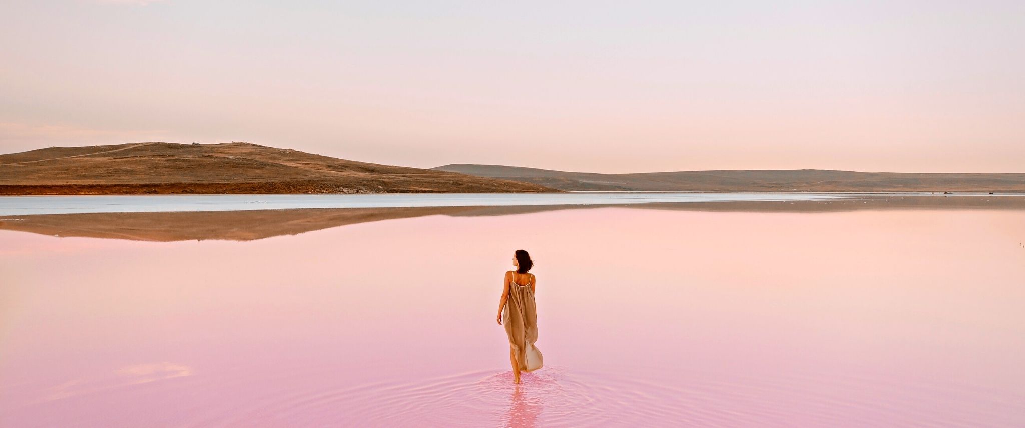 Femme marchant sur étendue d'eau rose