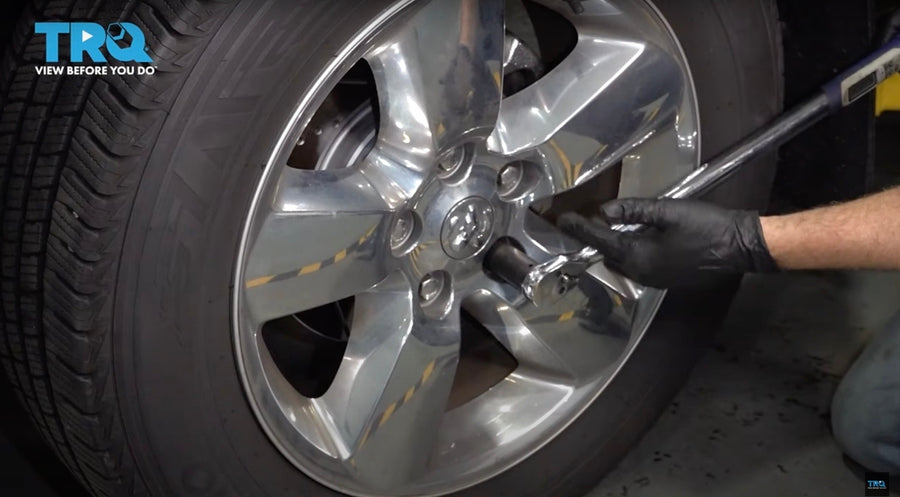 Man torquing lug nuts to replace wheel on Dodge Ram 1500