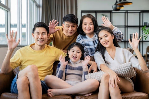 family-portrait-asian-multi-gneration-parent-grandparent-grandchild-sit-relax-together-smile-hand-wave-say-hi-look-camera-sofa-living-room-home-interior-background