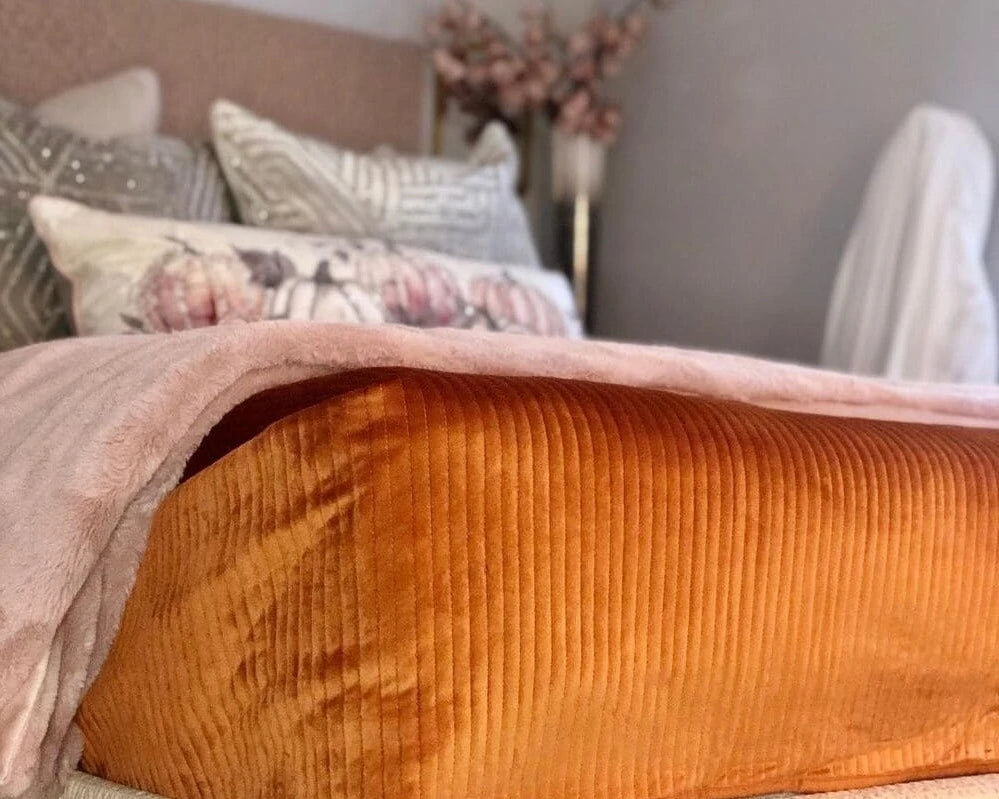 orange sheet and pillows on the bed