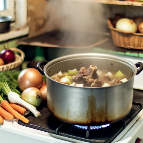 Image of a cozy kitchen scene featuring oxtail soup being cooked. The image should display a large pot on a stove filled with simmering oxtail soup