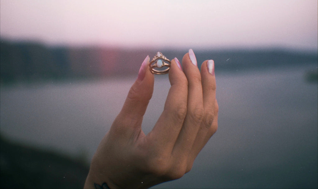 Iron Oxide Solitude Collection Hand Holding the Halo Stacking Ethical Engagement and Wedding Ring Set