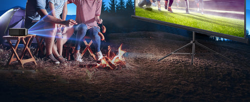 A family enjoying an outdoor setting with a bonfire, using this projector to watch a rugby match. 