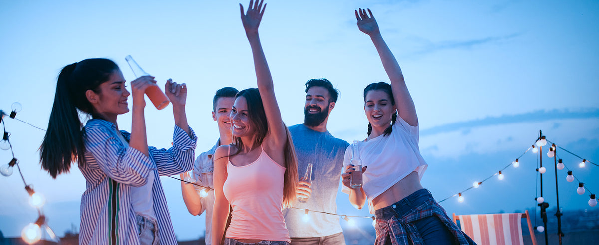 Five people having an outdoor party and dancing.