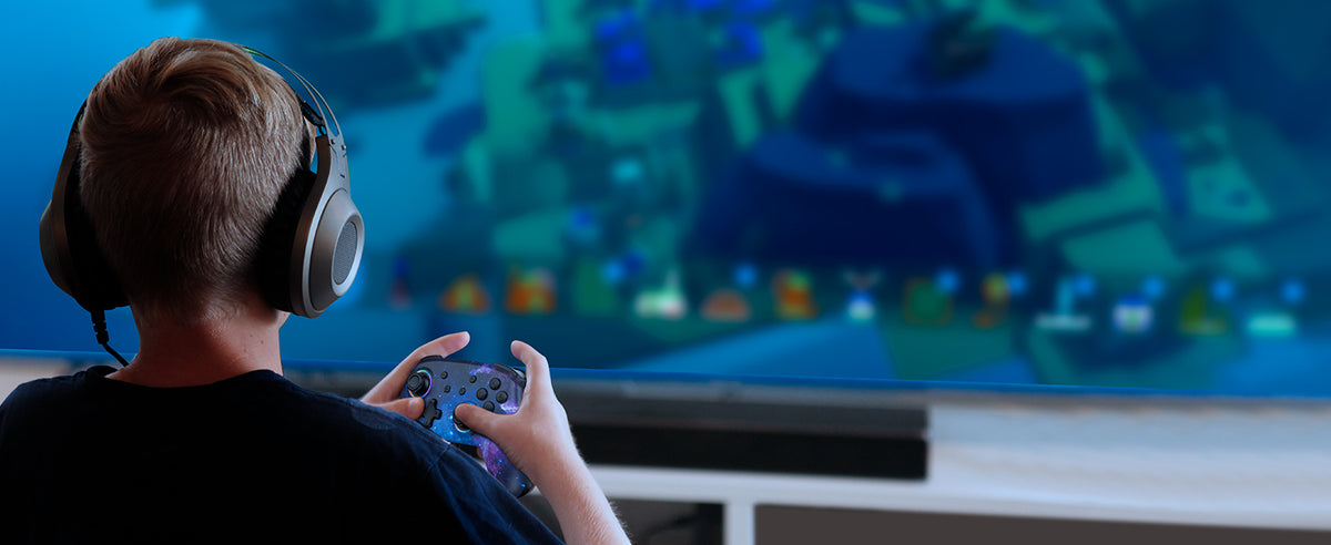 A child wearing headphones, immersed in gaming using the controller.