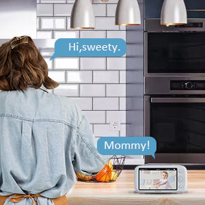 The mother cooks while having a conversation with the baby through the monitor.