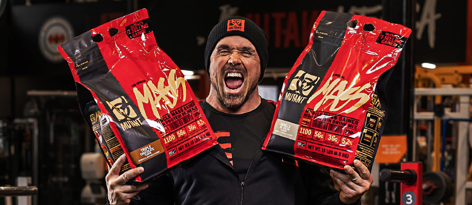 In the image, MUTANT Athlete Ron Partlow holds a large bag of MUTANT Mass in each hand while grimacing.