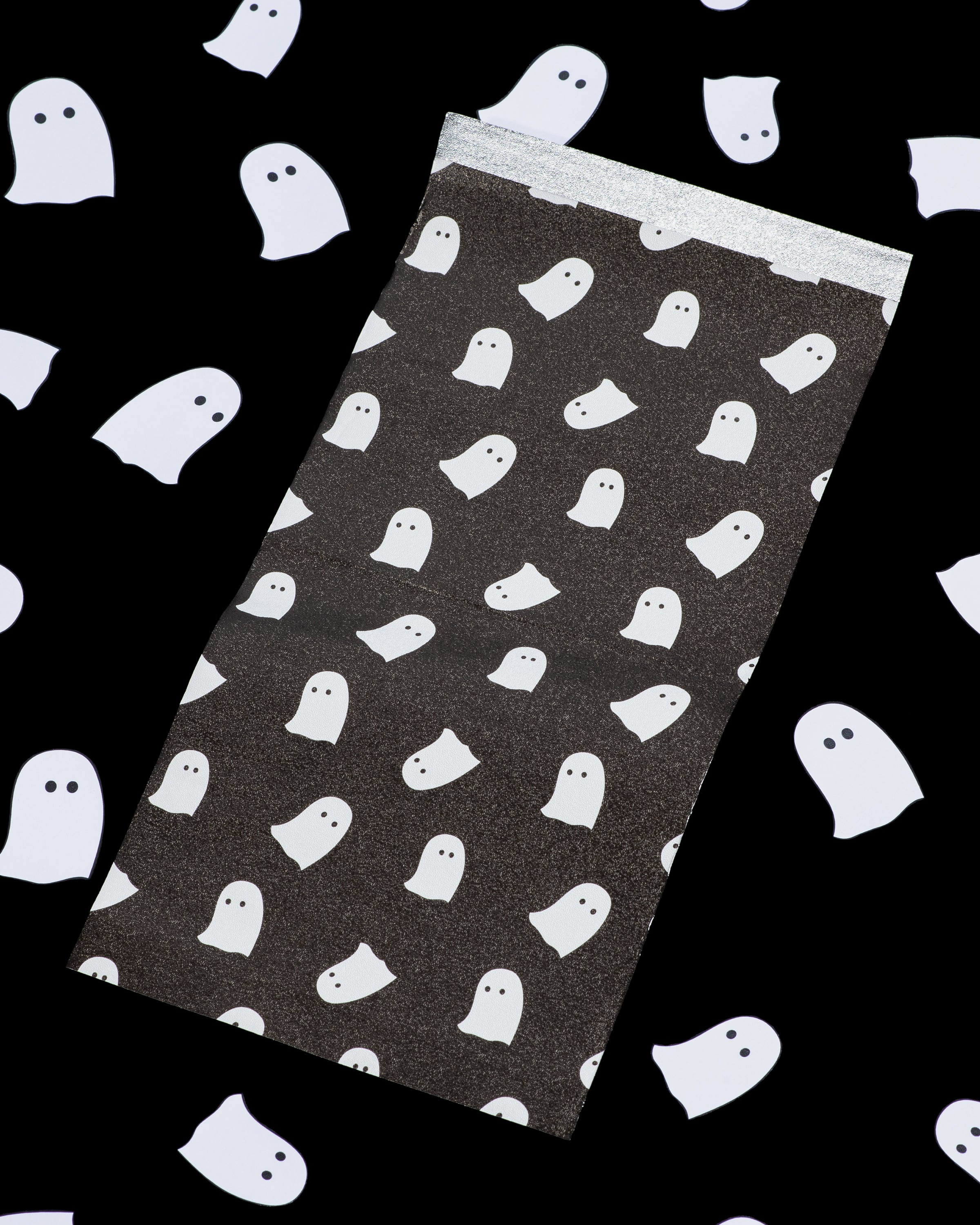 Black gift wrapping paper with white ghost print pattern.