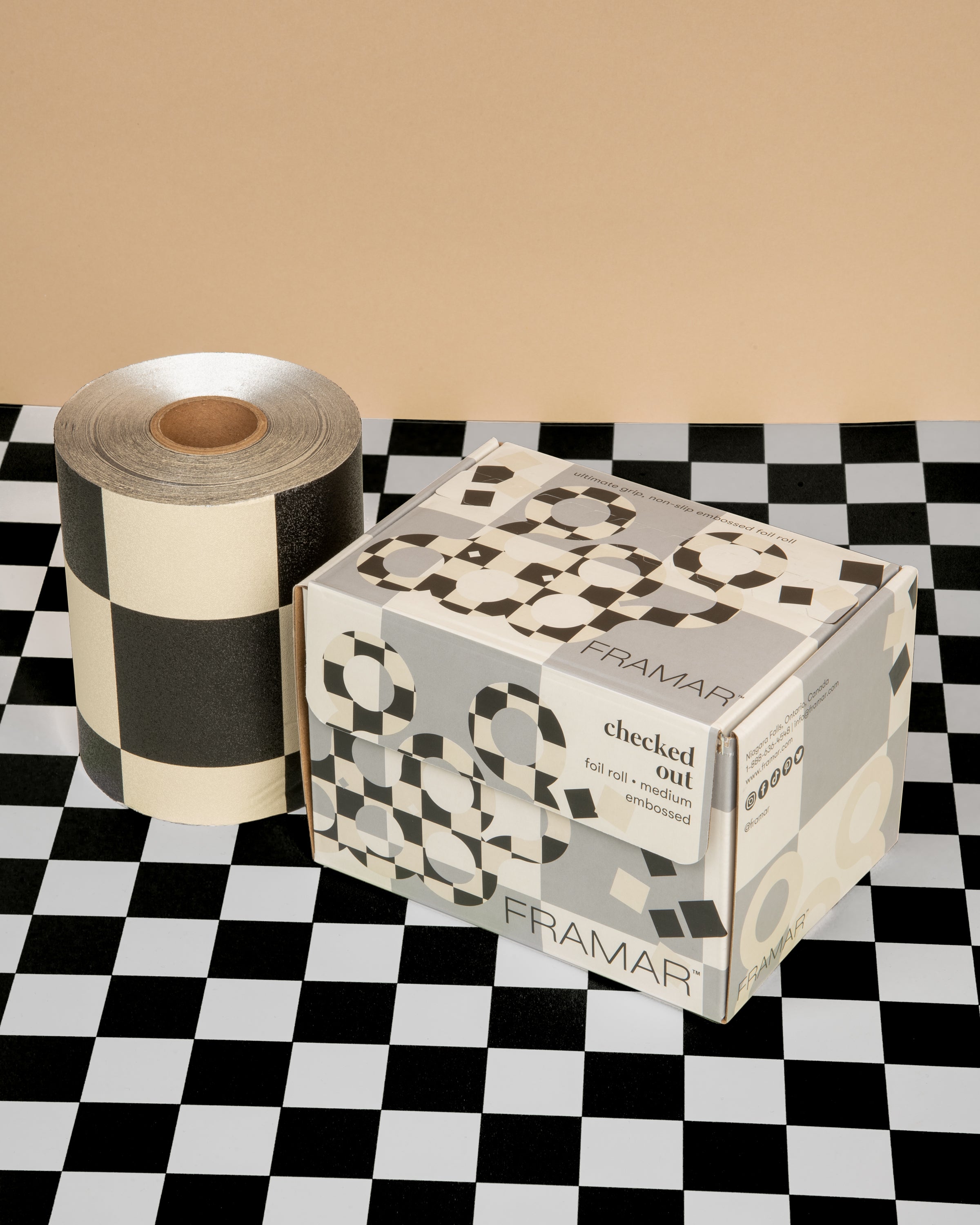 Roll of hair foils next to its box on a checkered background.