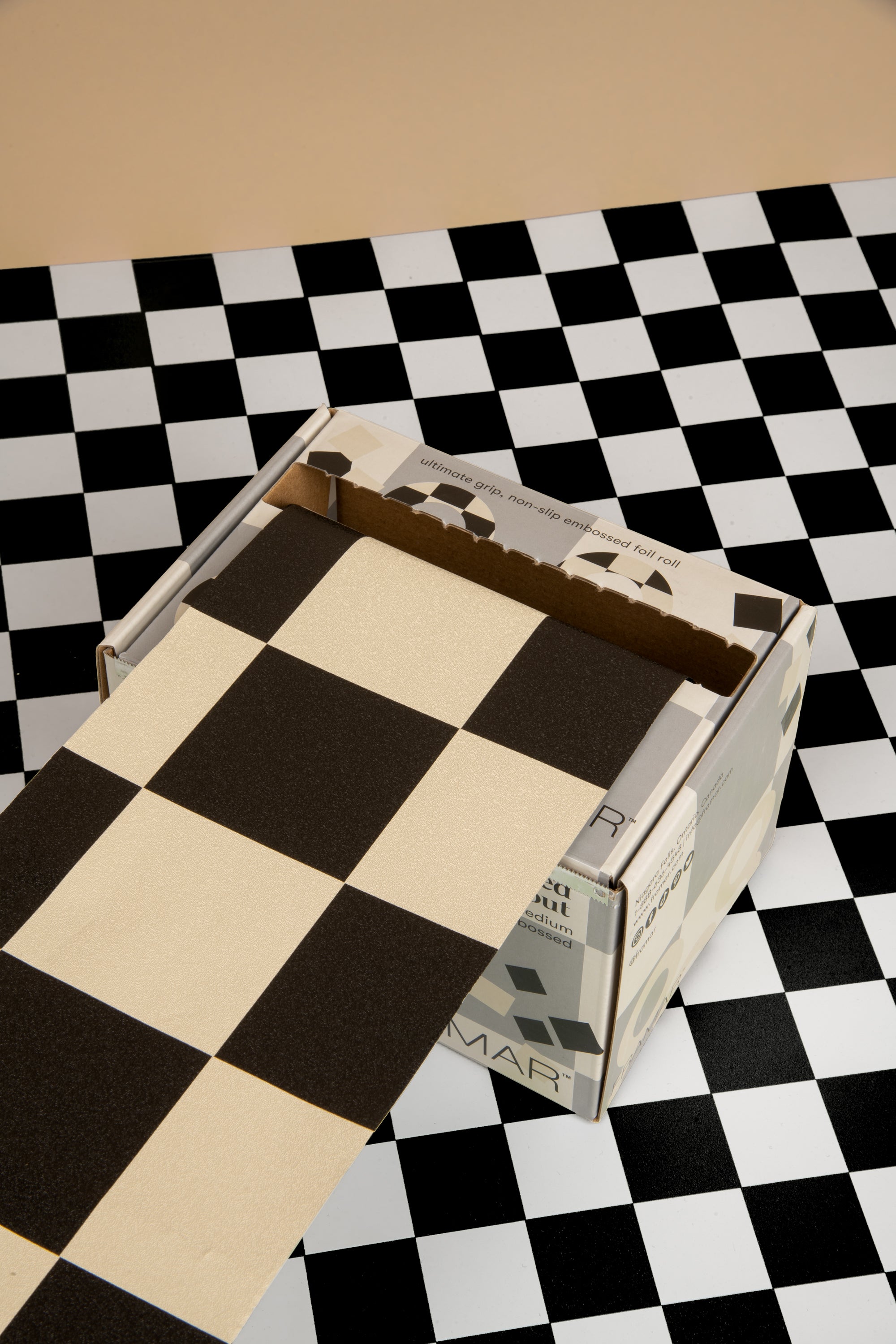 An open box on a checkered surface with a checkered pattern on the box flap.