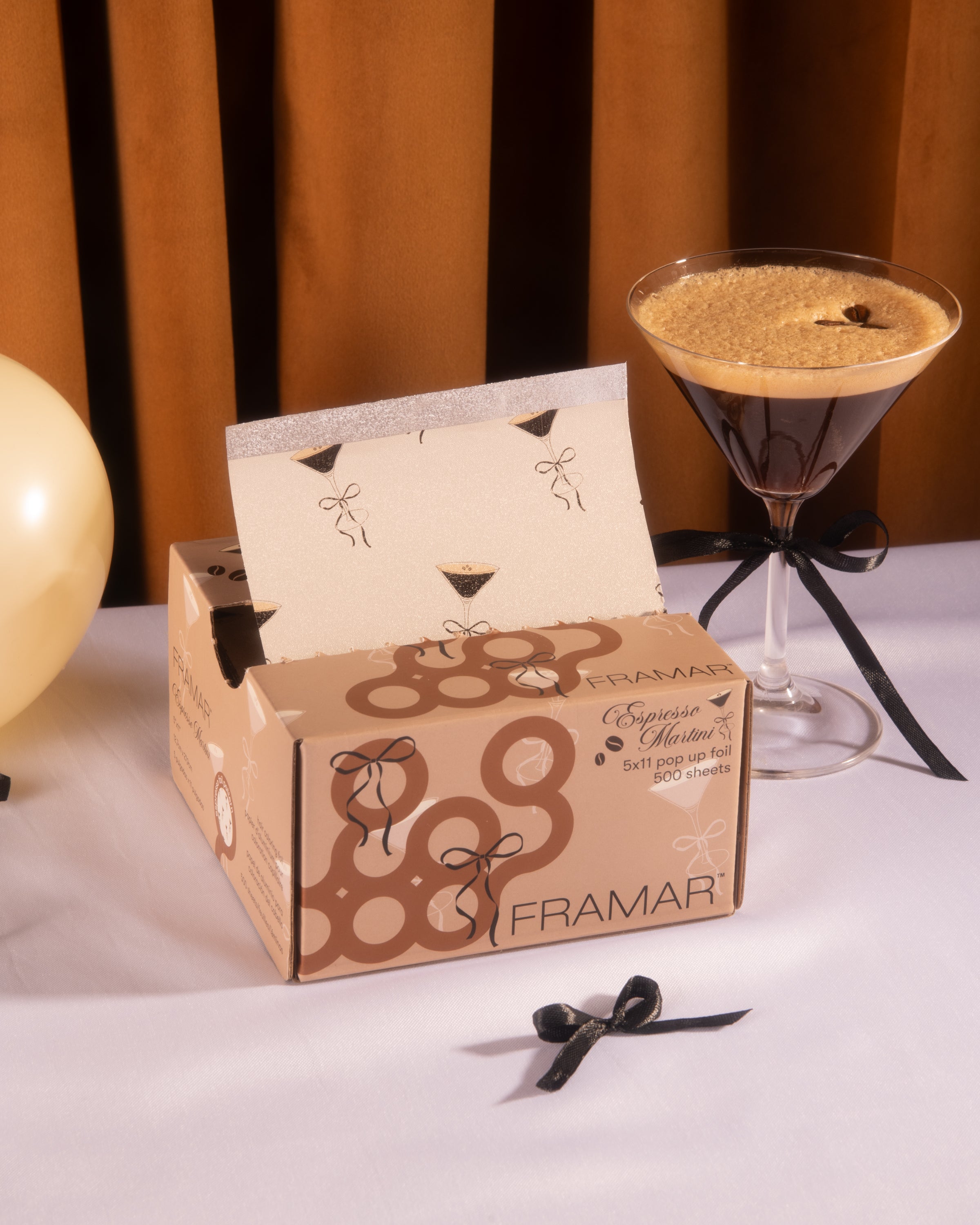 A box of pop-up foils beside an espresso martini glass.