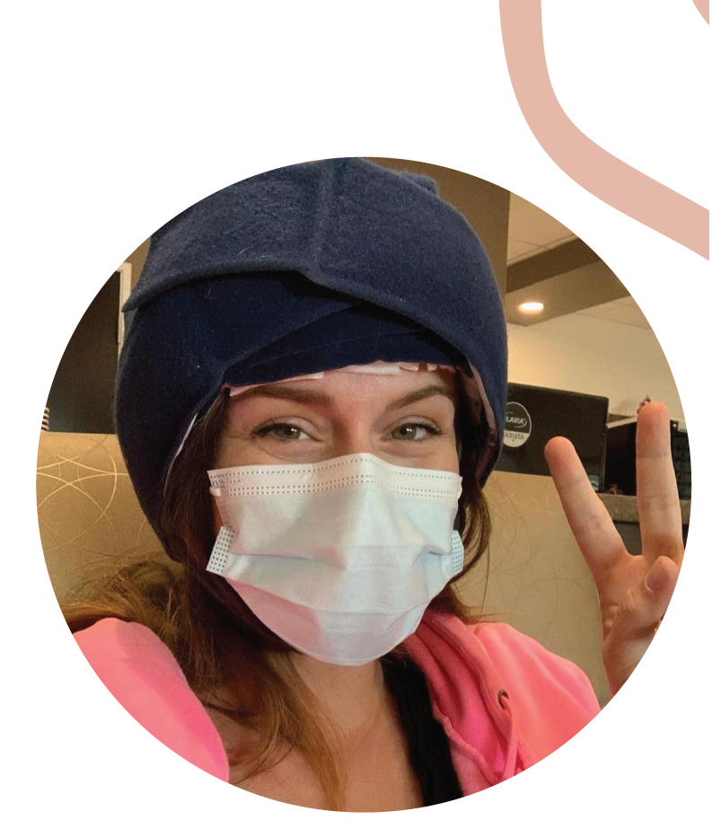 Person wearing a blue headwrap and face mask, showing a peace sign.