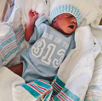 Newborn with a Born in the 313 baby onsie - Pure Detroit x DMC