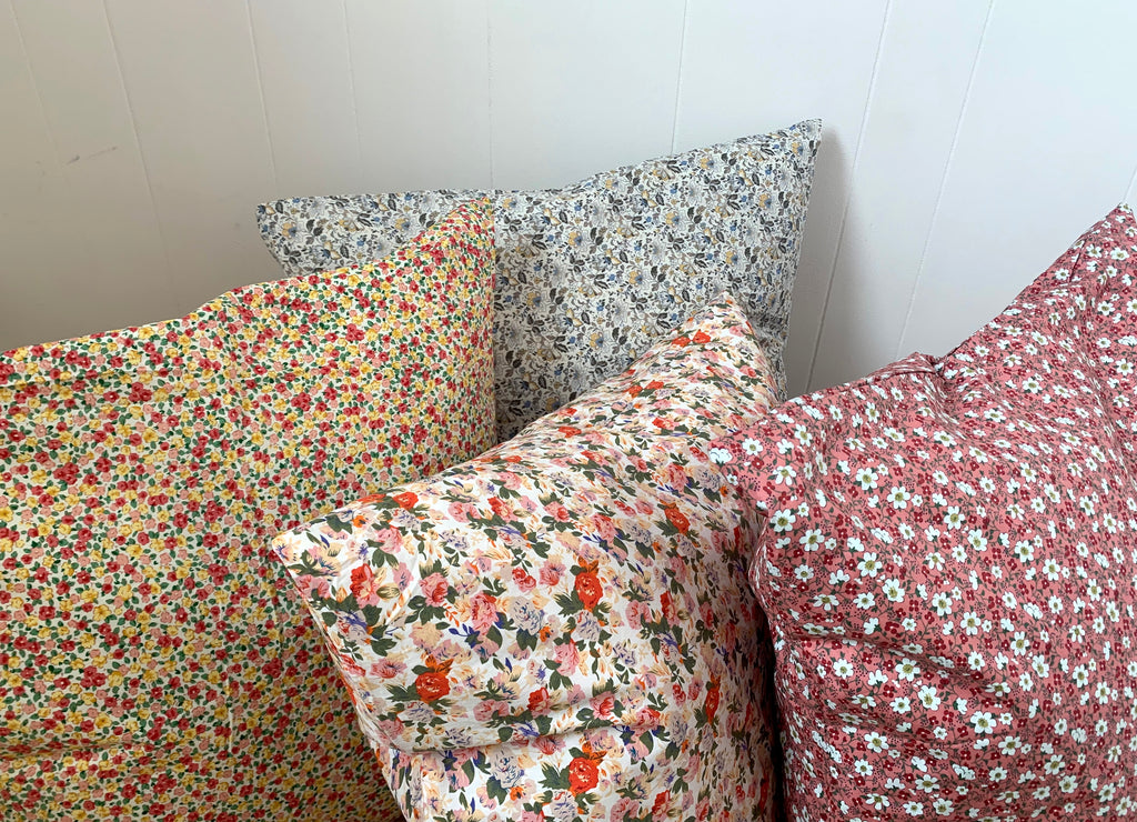 four cushions with colourful floral prints grouped together 
