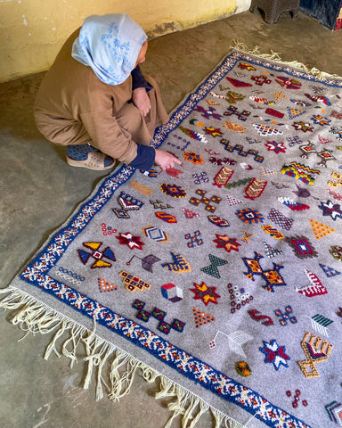 Khadija Inspecting a Carpet