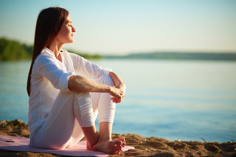 Serene woman sitting outdoors near a lake