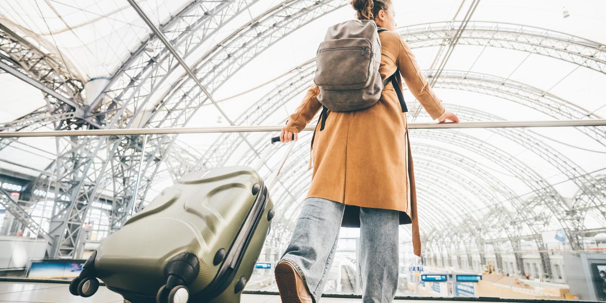 femme en voyage avec sac à dos et valise