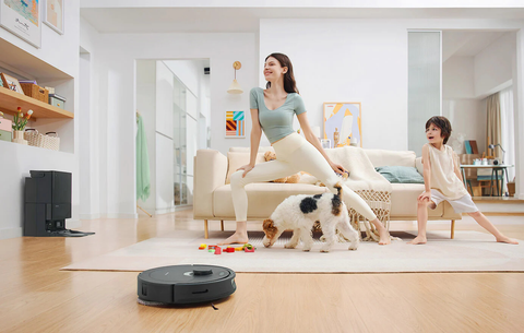 Family with pets using a Roborock smart vacuum cleaner to clean the floors.