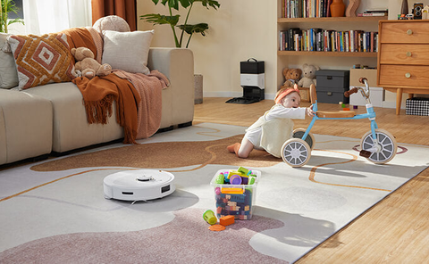 A white Roborock Q8 Max is cleaning the babyroom's carpet.