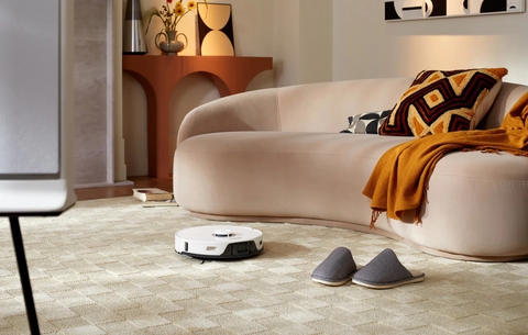 A white Roborock S8 Pro Ultra smart vacuum cleaner is cleaning carpets.