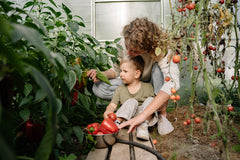 Woman gardening in a greenhouse with her child