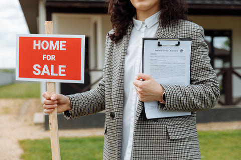 Woman holding a home sold sign
