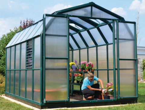 Woman shown gardening inside of Rion Prestige Greenhouse