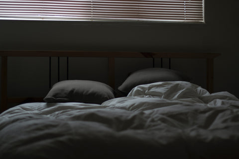 a cozy looking bedroom in a dim room