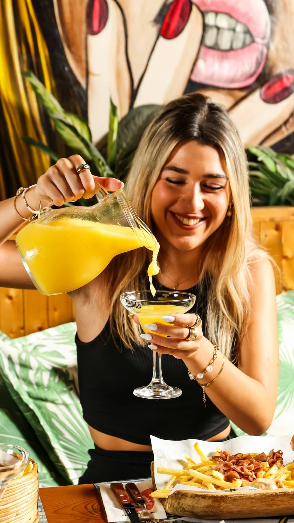 A woman holding a mango mixed drink