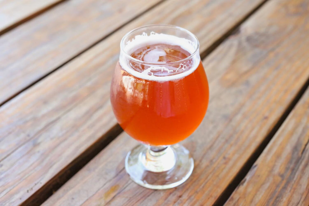 A glass of sour ale on a wooden table