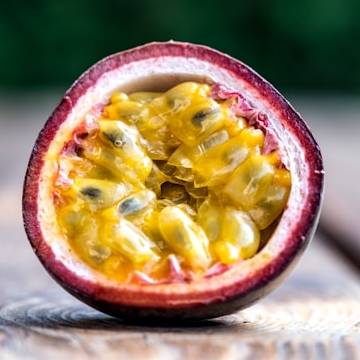 half of passion fruit on wooden surface