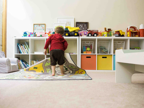 A child play on an area rug in his playroom