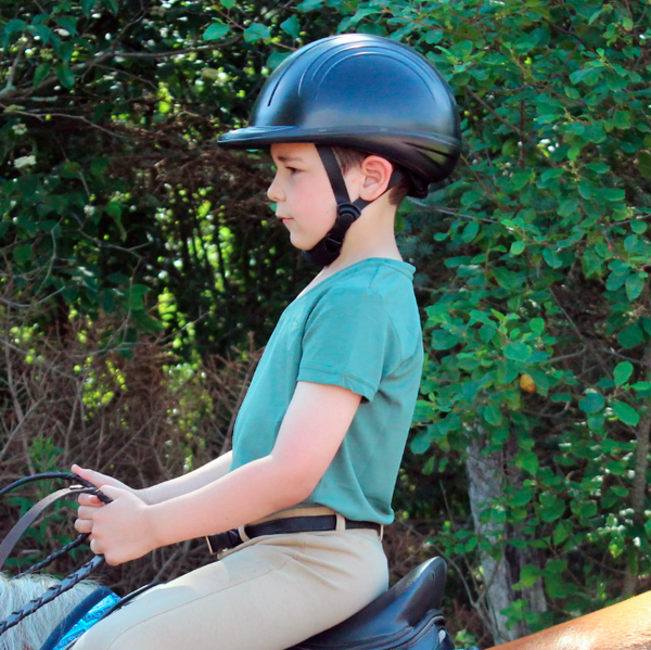 young boy wearing TuffRider children's riding hat