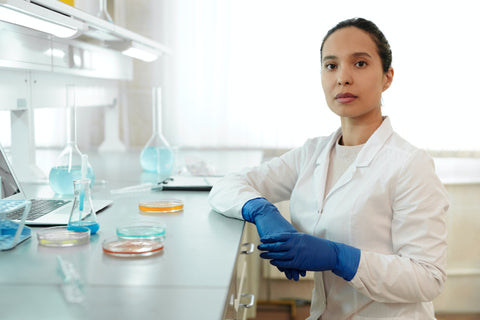 Woman in lab coat with vials for testing